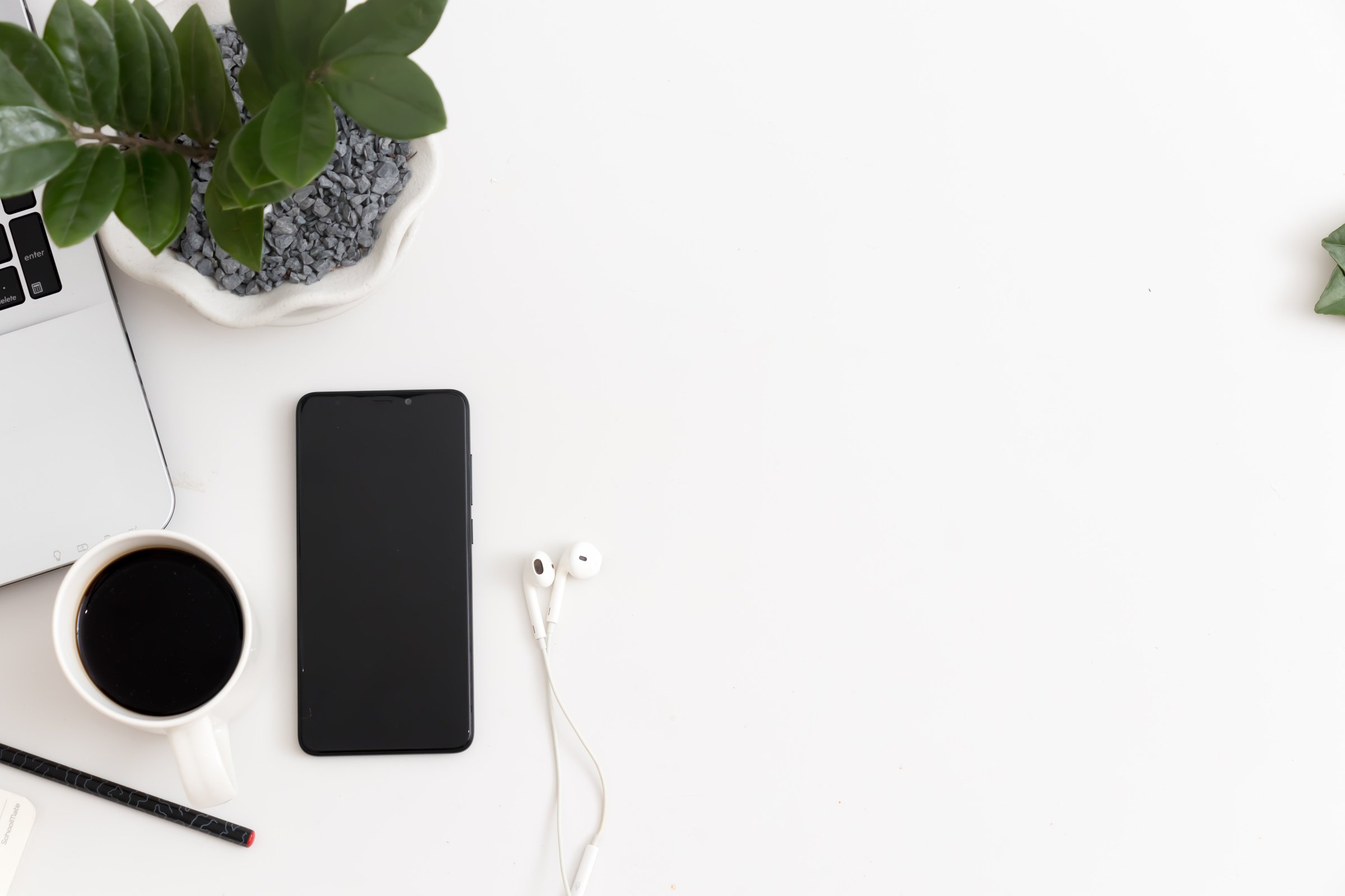 White office desk with mobile phone notebook pen office plant